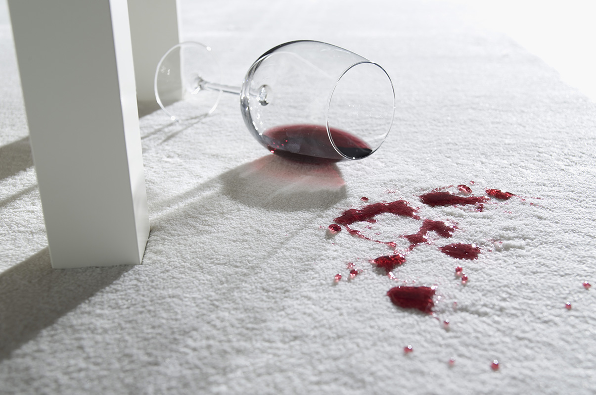 Rotweinglas auf Teppich