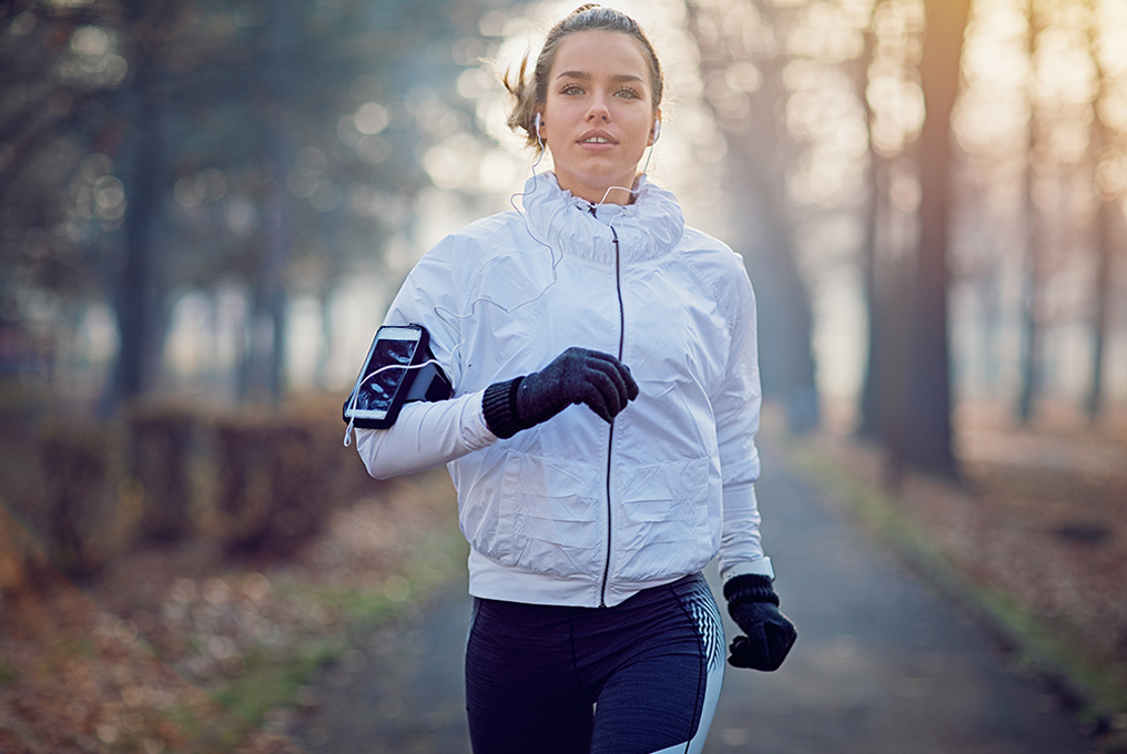 una donna fa jogging nel bosco.