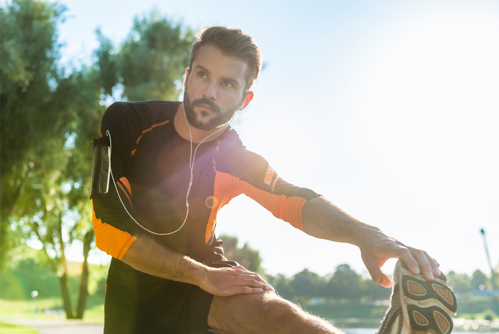 Mann dehnt sich draussen