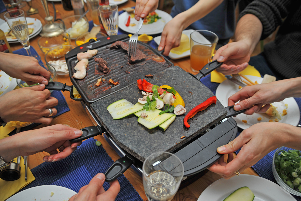 Eine Familie an Weihnachten isst Raclette.