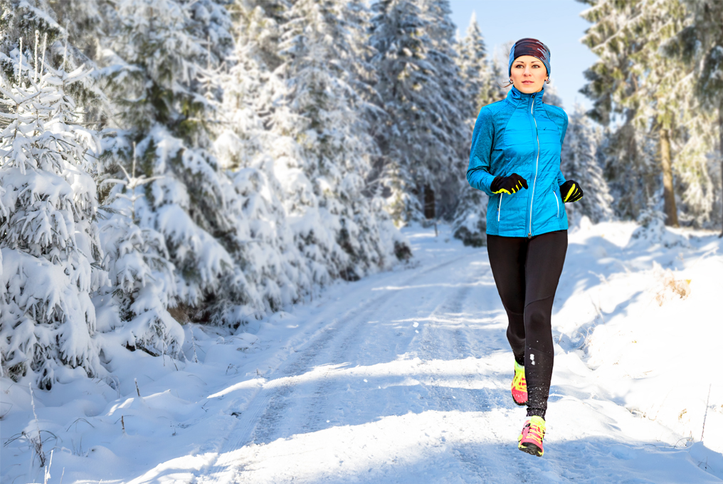 Eine Frau joggt im Schnee.