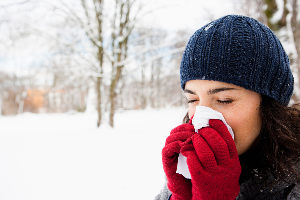 Eine Frau putzt ihre Nase im Wald.