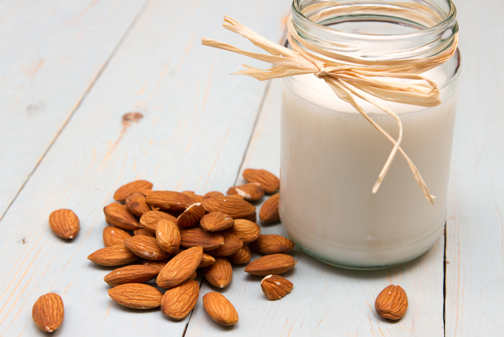Ein Einmachglas Mandelmilch mit Mandeln.