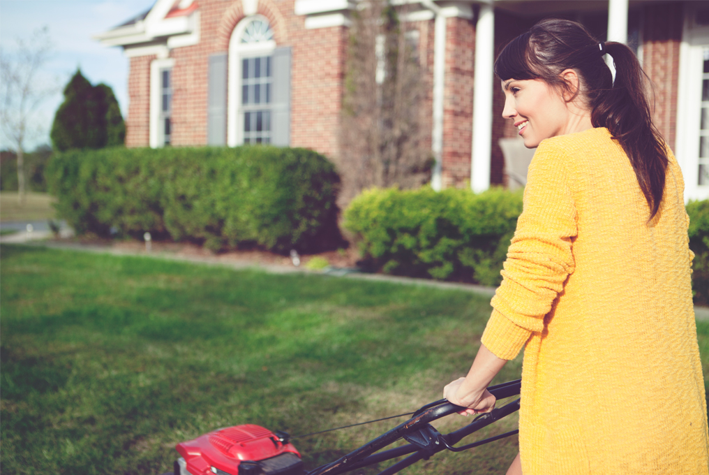 Eine Frau mäht den Rasen.