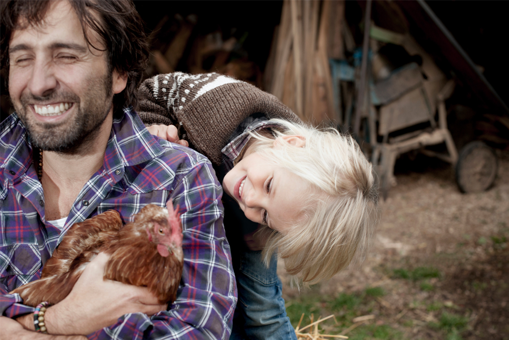 Padre e figlio che giocano con i polli