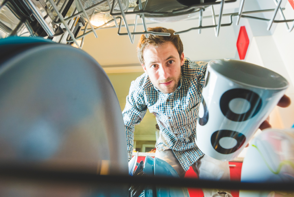 Un uomo sembra confuso in lavastoviglie.