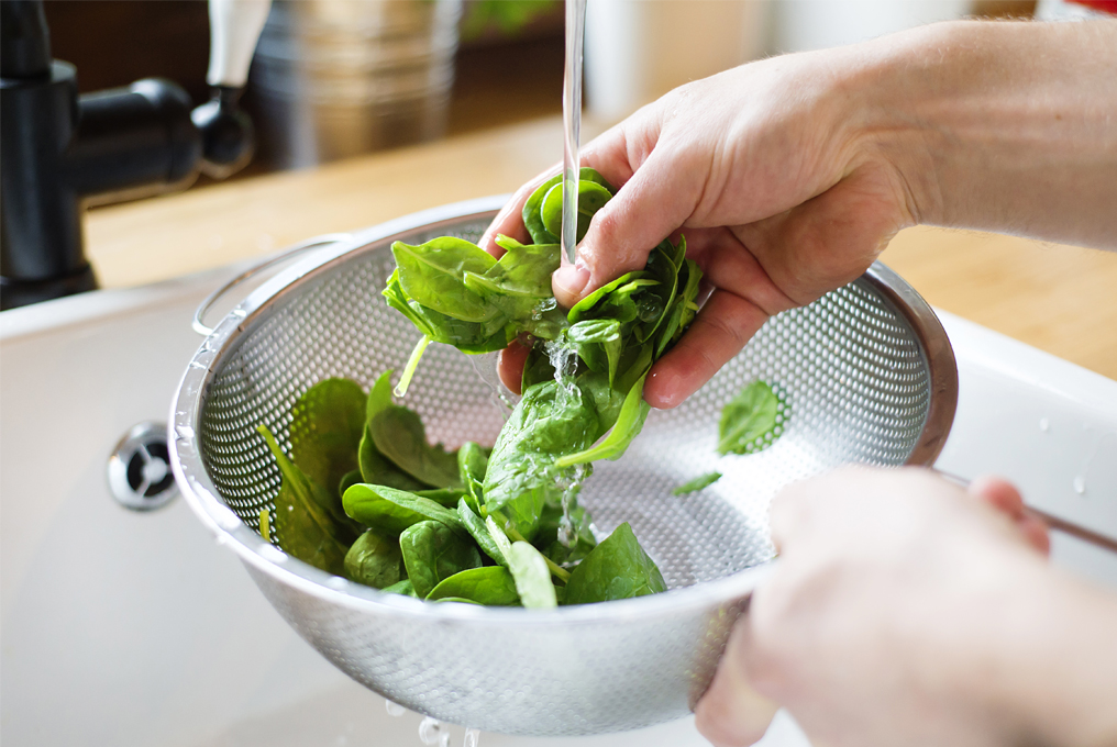 Spinat in einem Sieb waschen.
