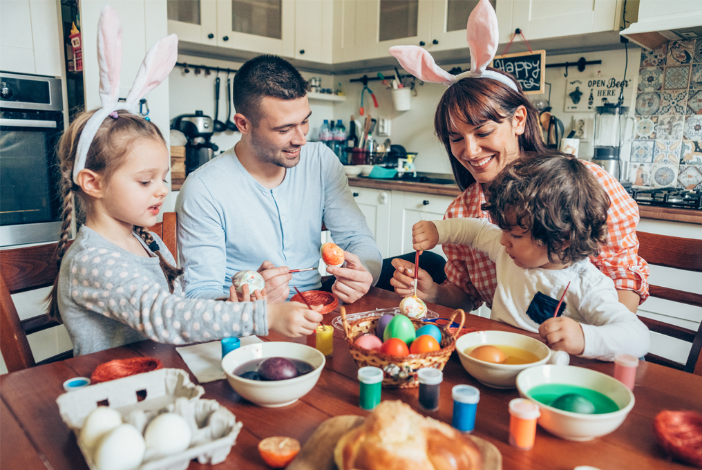 Una famiglia dipinge le uova di Pasqua