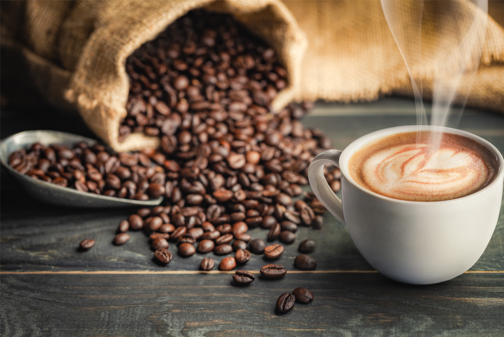 Eine Tasse Kaffee mit einem Sack Kaffebohnen nebendran