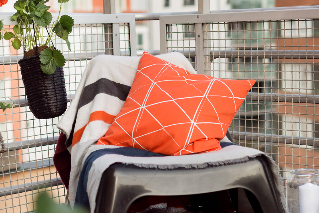 Une chaise longue avec un oreiller orange dessus