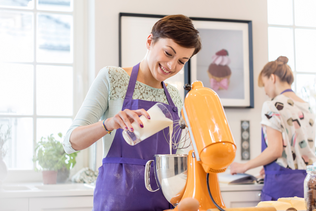 Zwei Frauen sind in einer Küche und mixen etwas