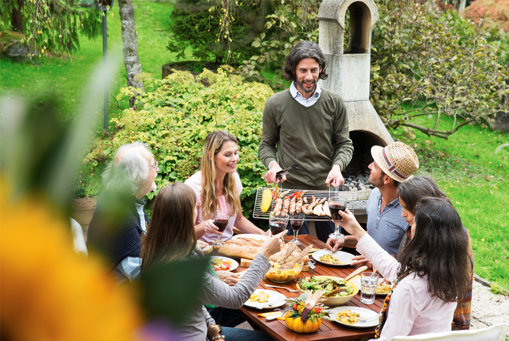 Amici in giardino a fare il barbecue e a mangiare