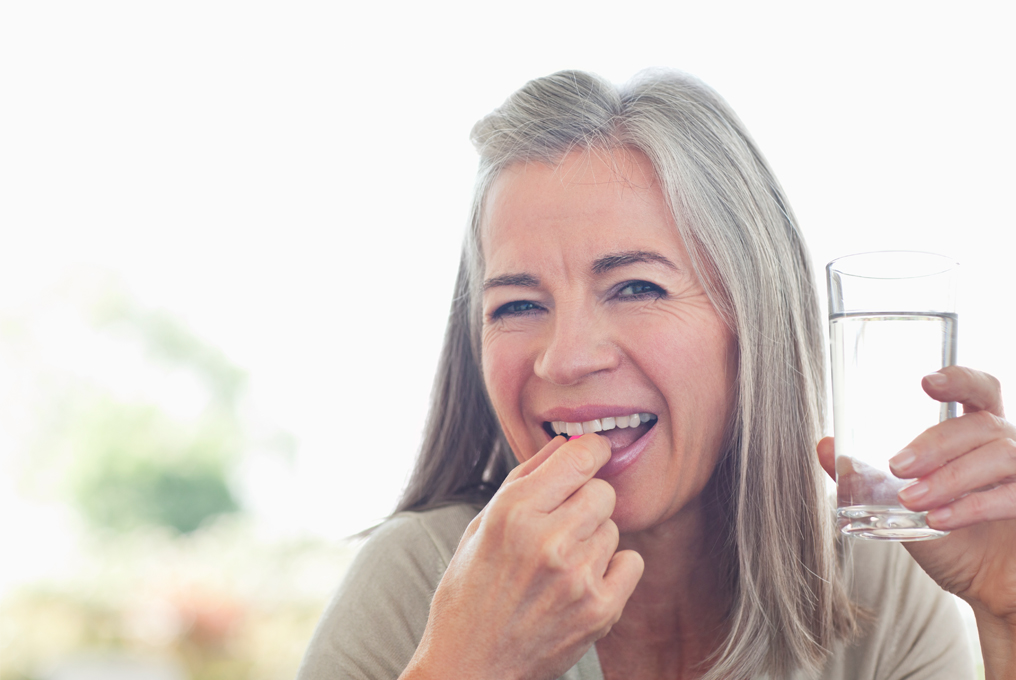 Eine ältere Frau nimmt Nahrungsergänzungsmittel