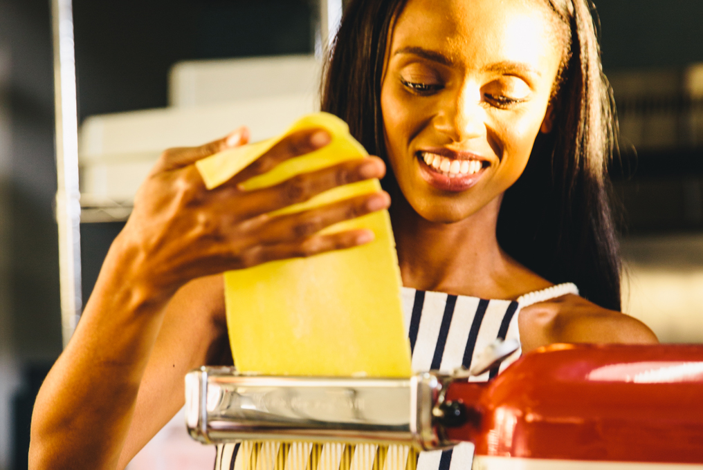 Une femme qui fait des pâtes avec une machine à pâtes