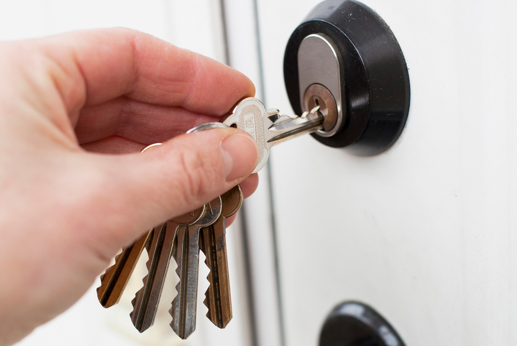 Ein man steckt den Schlüssel in das Türschloss