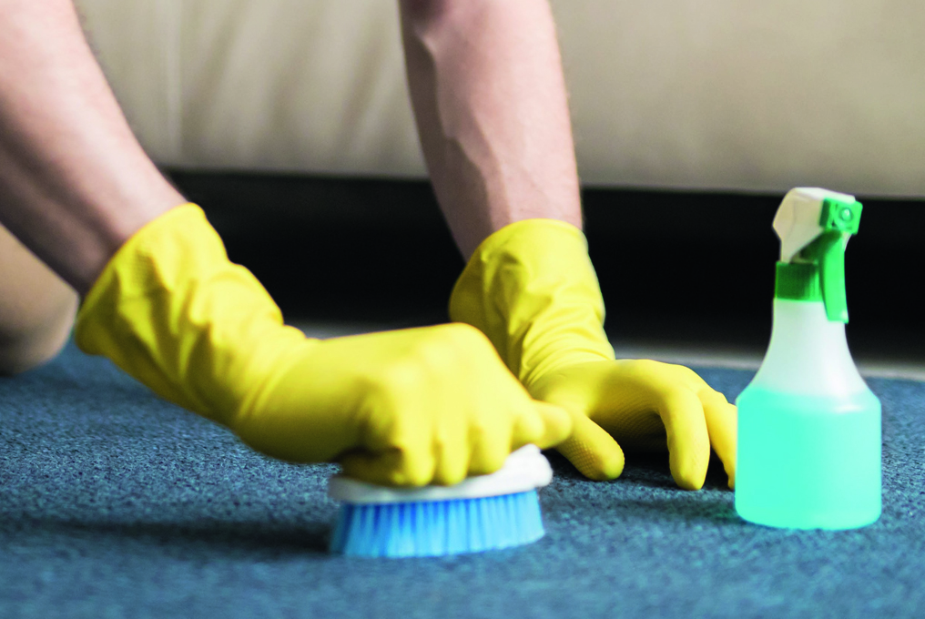 Un homme nettoie son tapis