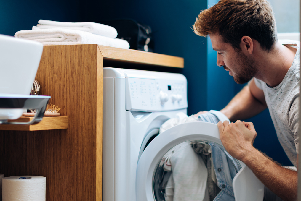 Ein Mann am Kleider waschen.