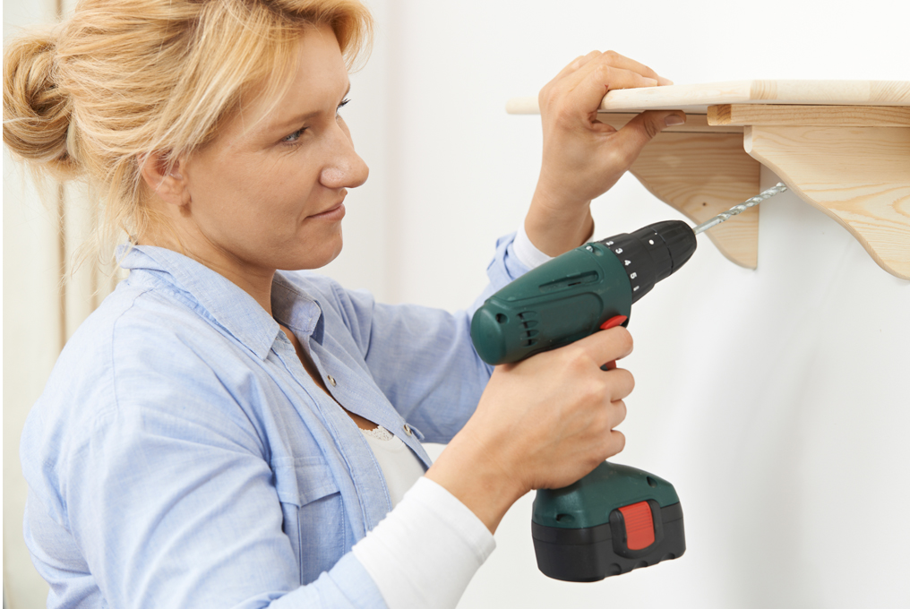 Eine Frau bohrt ein Loch