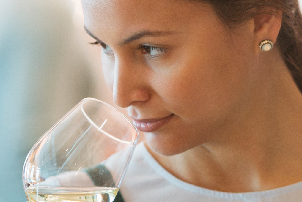 Una donna odora un bicchiere di gin