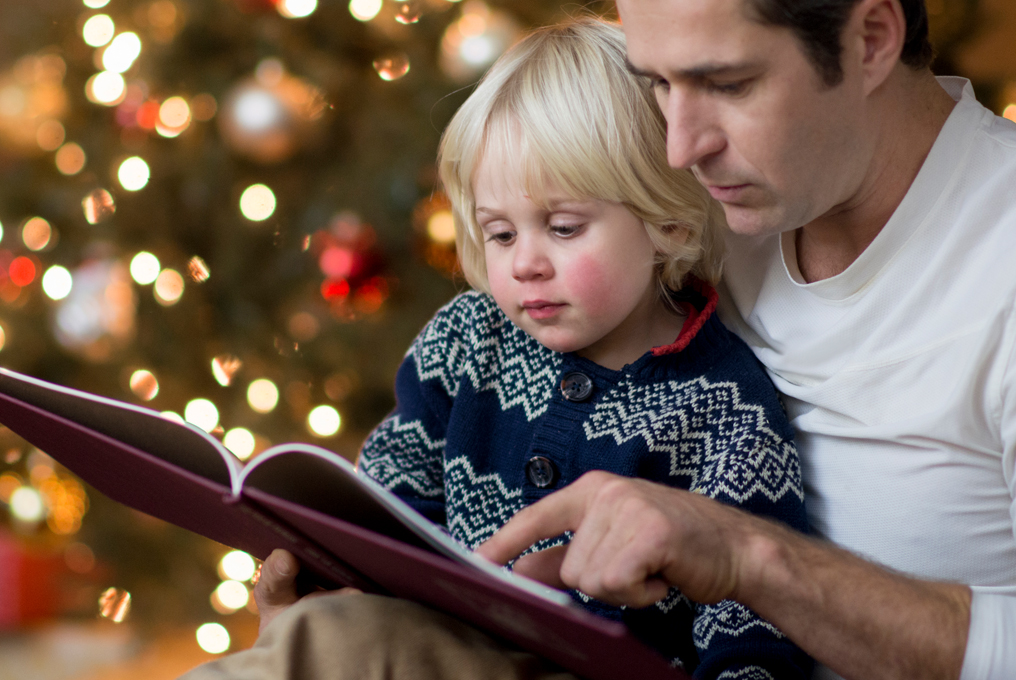 Eine Vater liest seinem Sohn eine Adventsgeschichte vor