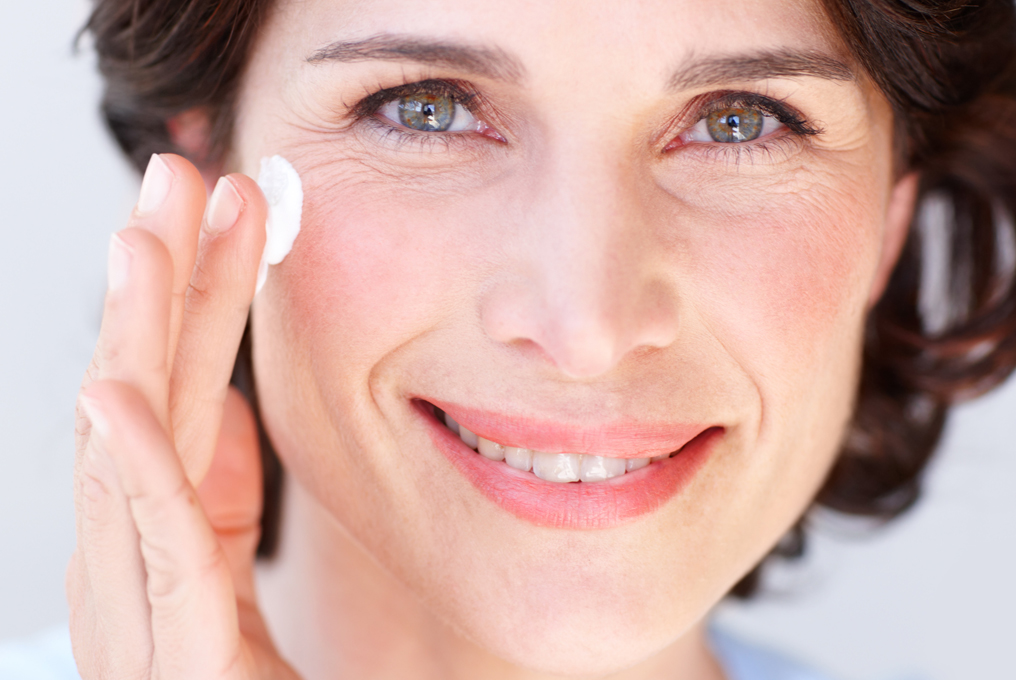 Eine Frau cremt ihr Gesicht ein