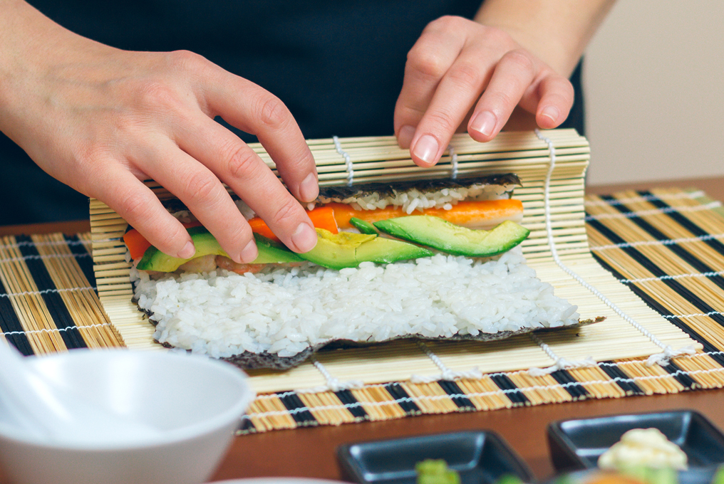 Eine Frau rollt Sushi