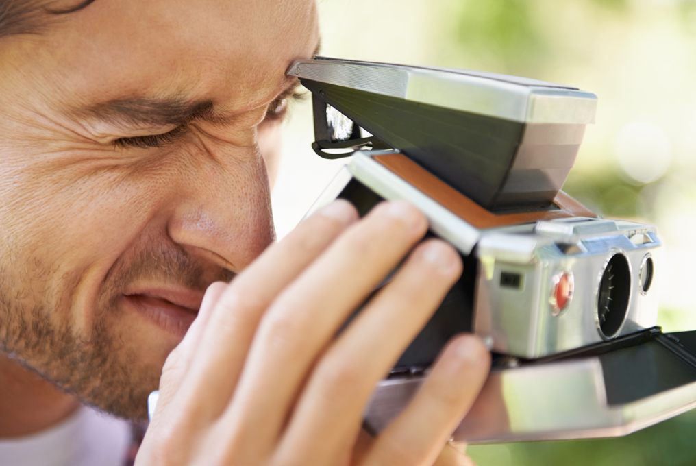 Un uomo con una macchina fotografica Polaroid