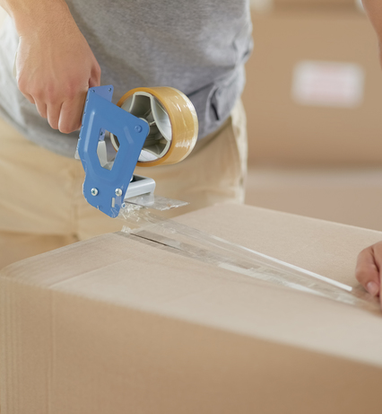 Mann schliesst mit Klebeband kartonschachtel