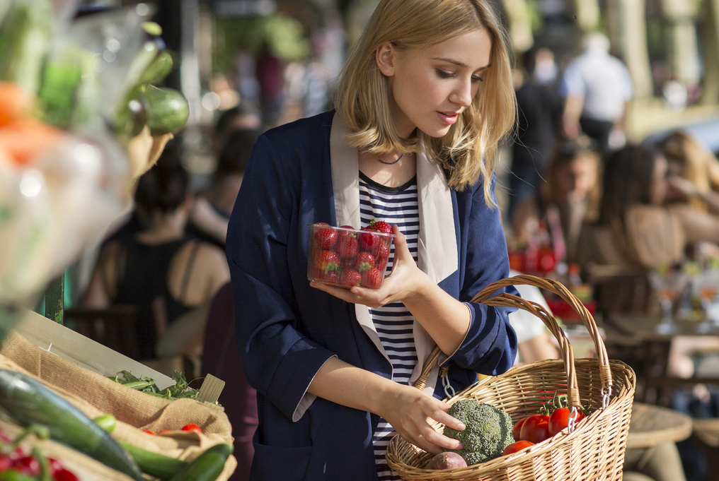 Une femme achète des légumes au marché