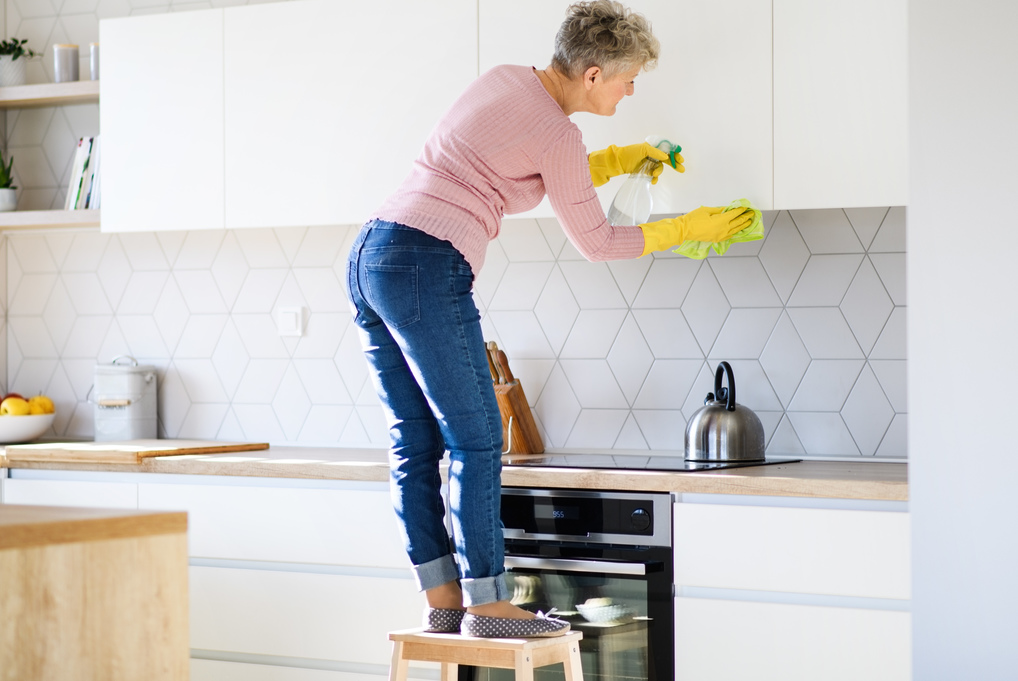 Femme nettoyant les armoires de cuisine