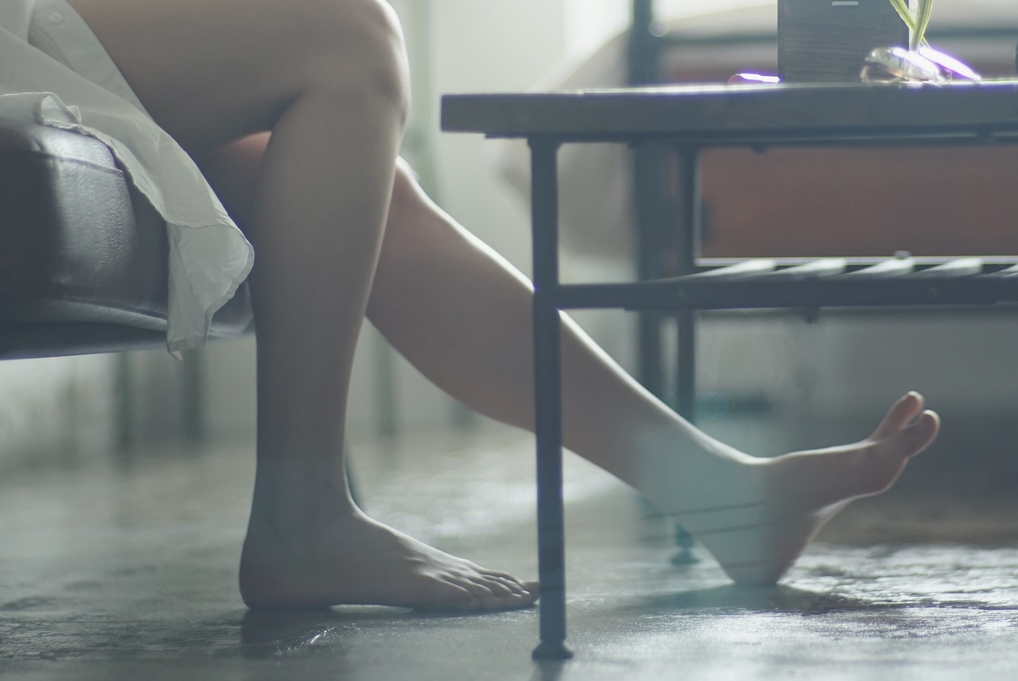 Une femme étire ses jambes tout en lisant un livre