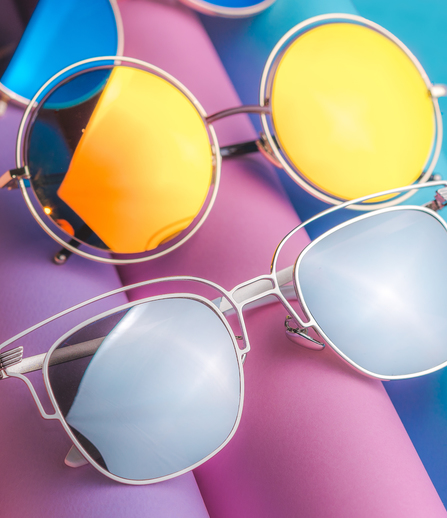 verschiedene Sonnenbrillen auf farbigem Hintergrund