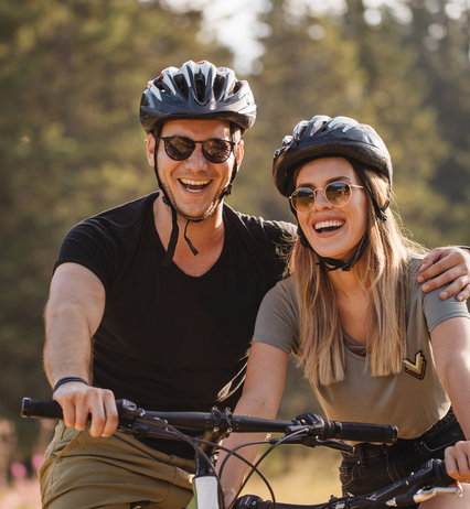 Coppia in bici, con casco e occhiali