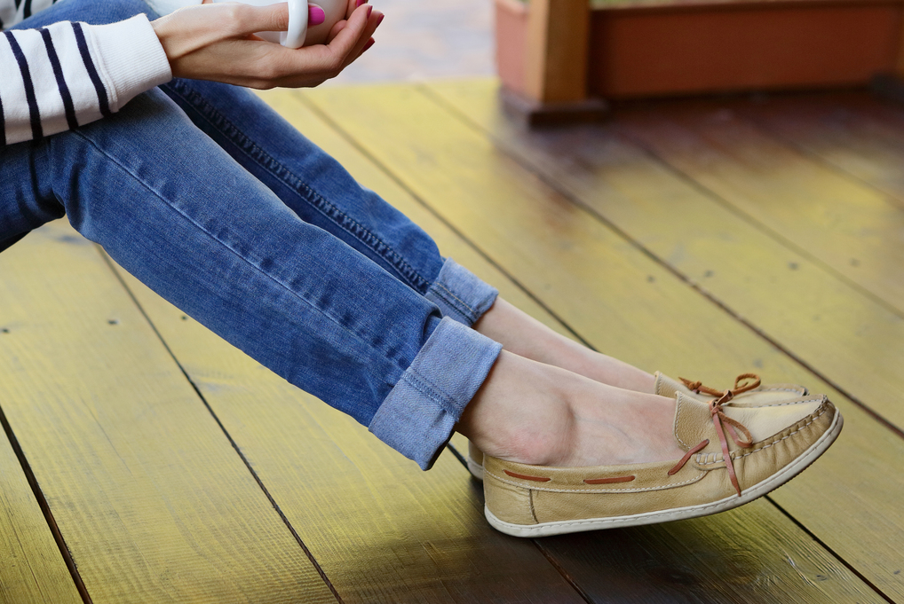 Frau in Jeanshosen und beigen Moccasins