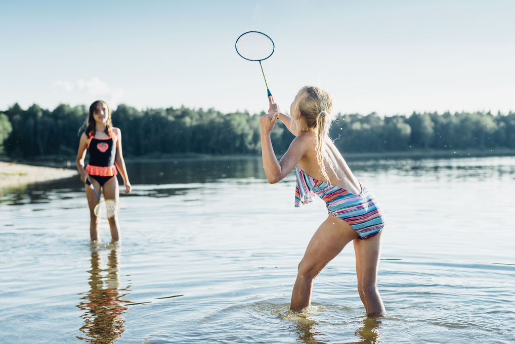 Kinder spielen Federball im See