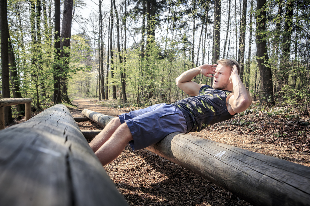 Hommes faisant des abdos dans un bois
