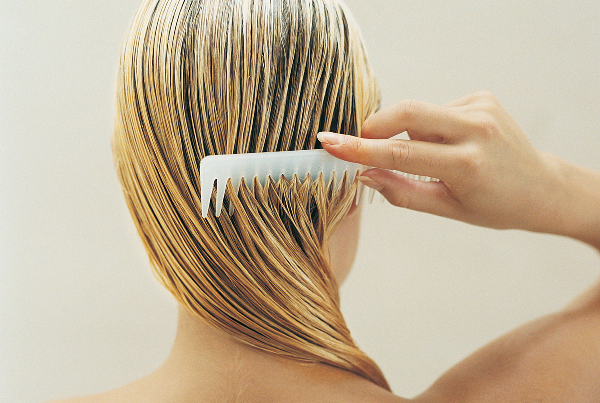 Donna si pettina i capelli bagnati