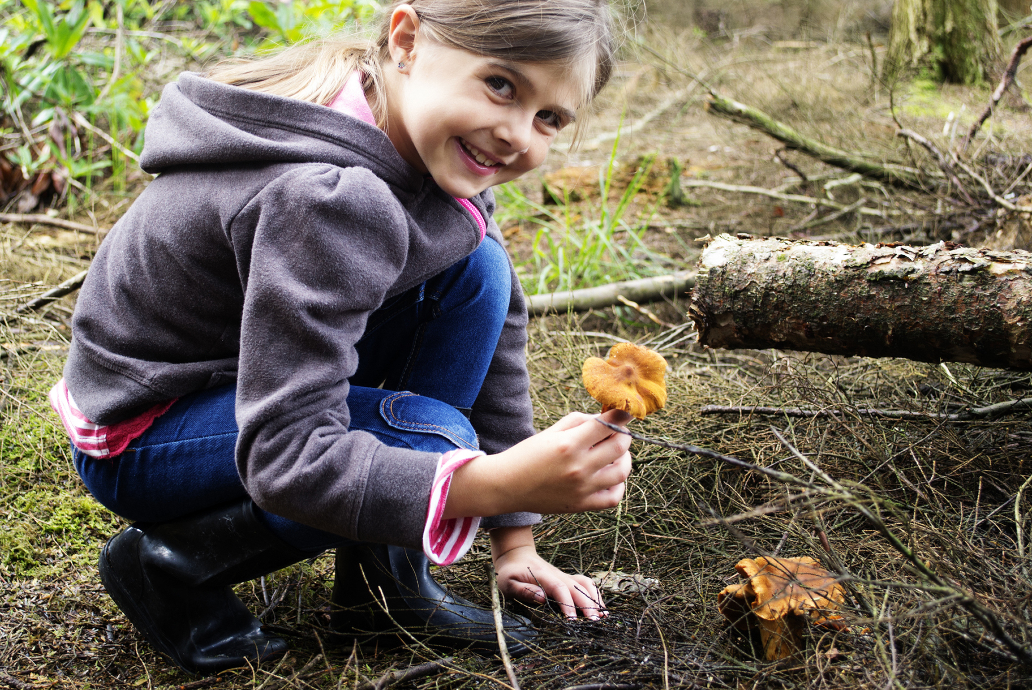 Mädchen im Wald mit Pilz in der Hand