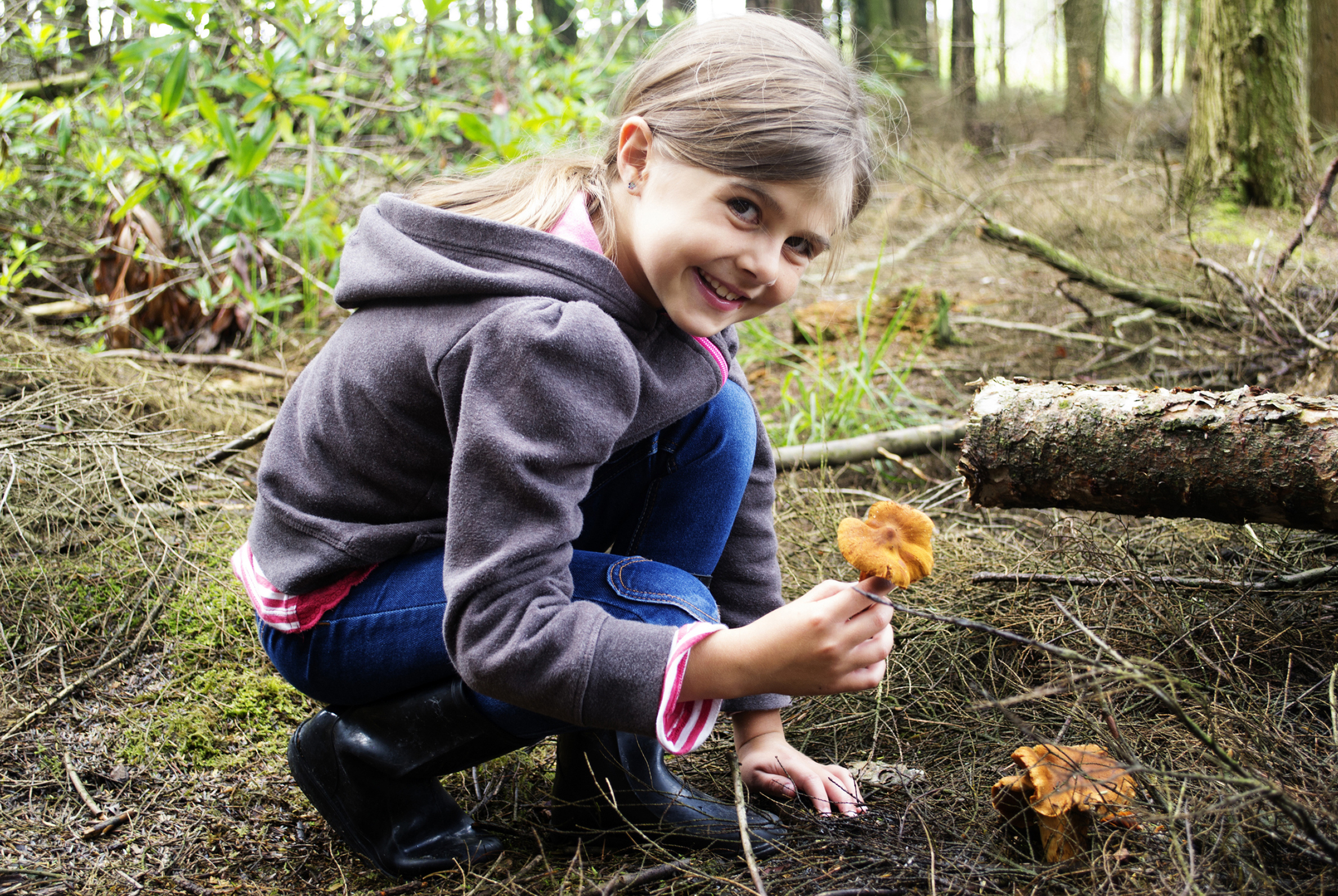 Ragazza nella foresta con un fungo in mano