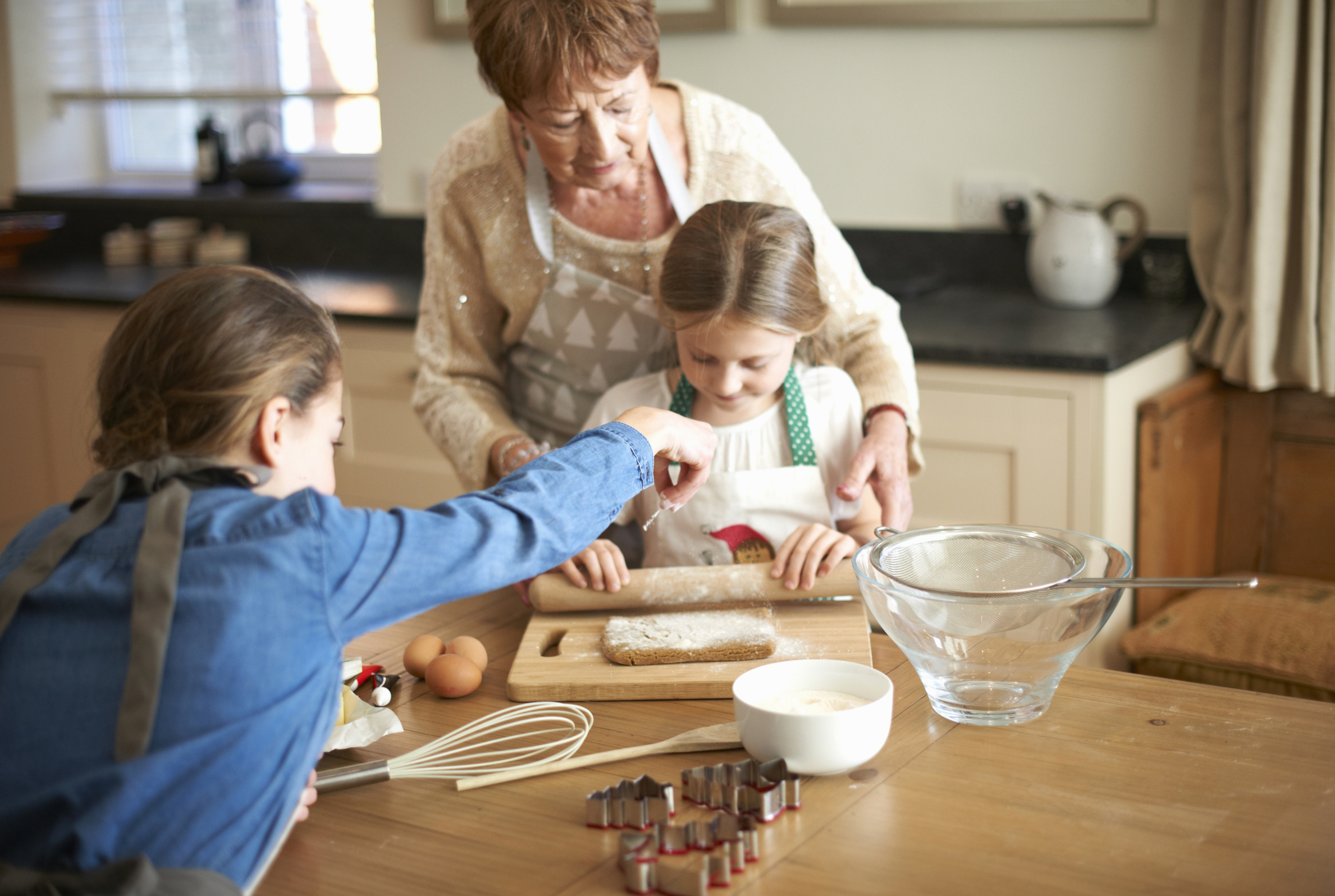 Kinder mit Grossmutter am Backen