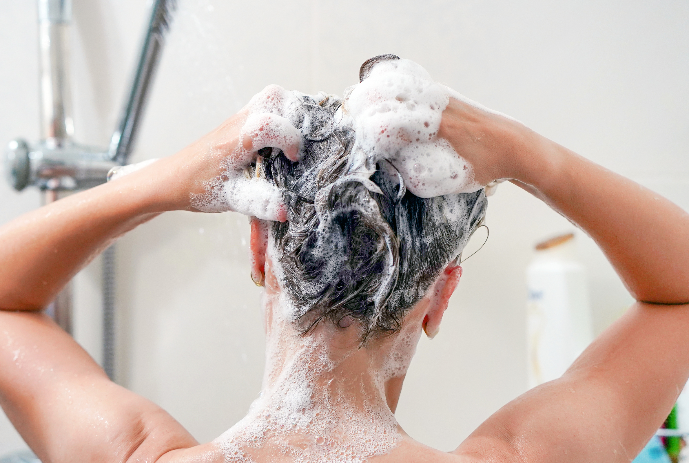 Frau schamponiert Haare