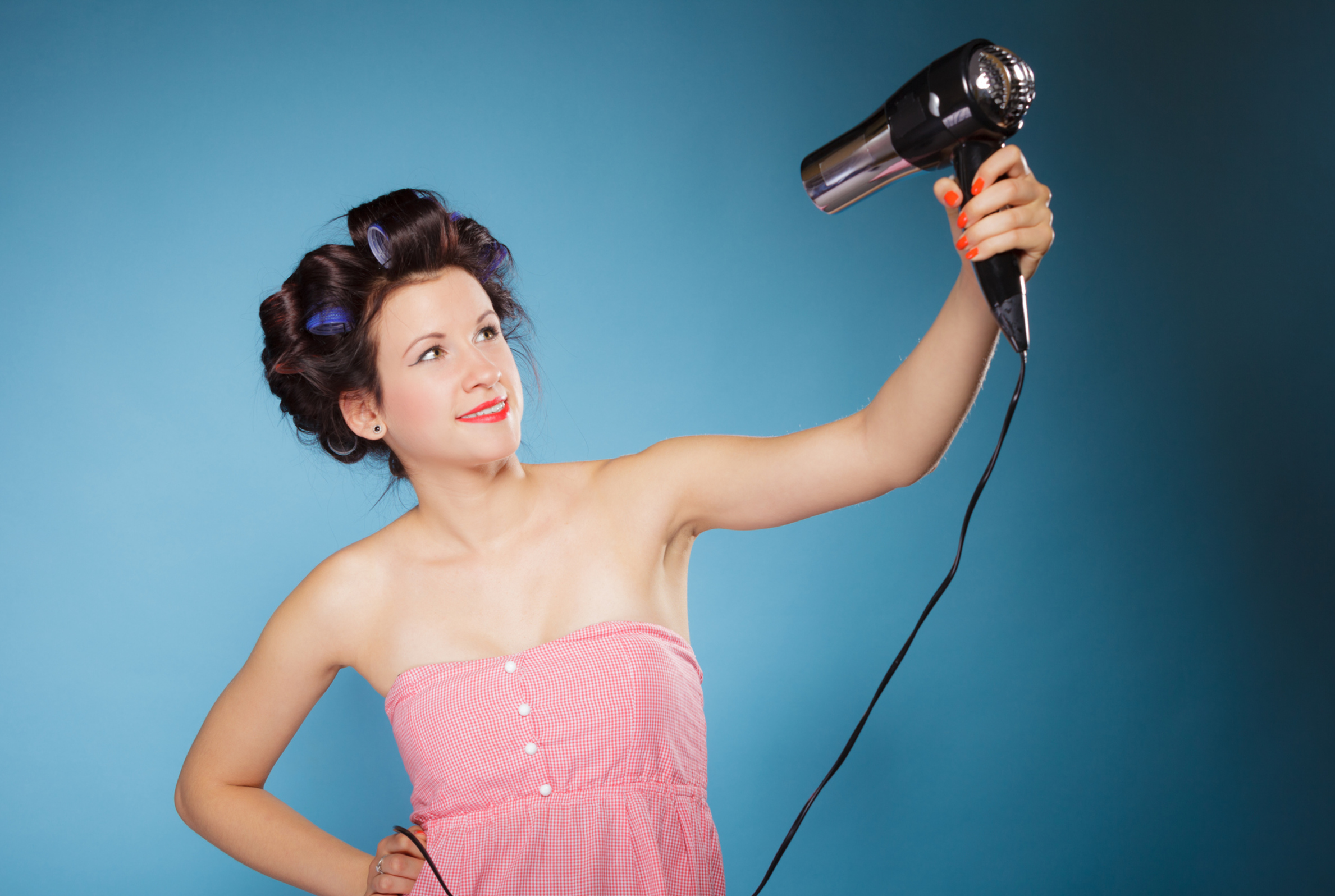 Frau mit Lockenwickler und Föhn