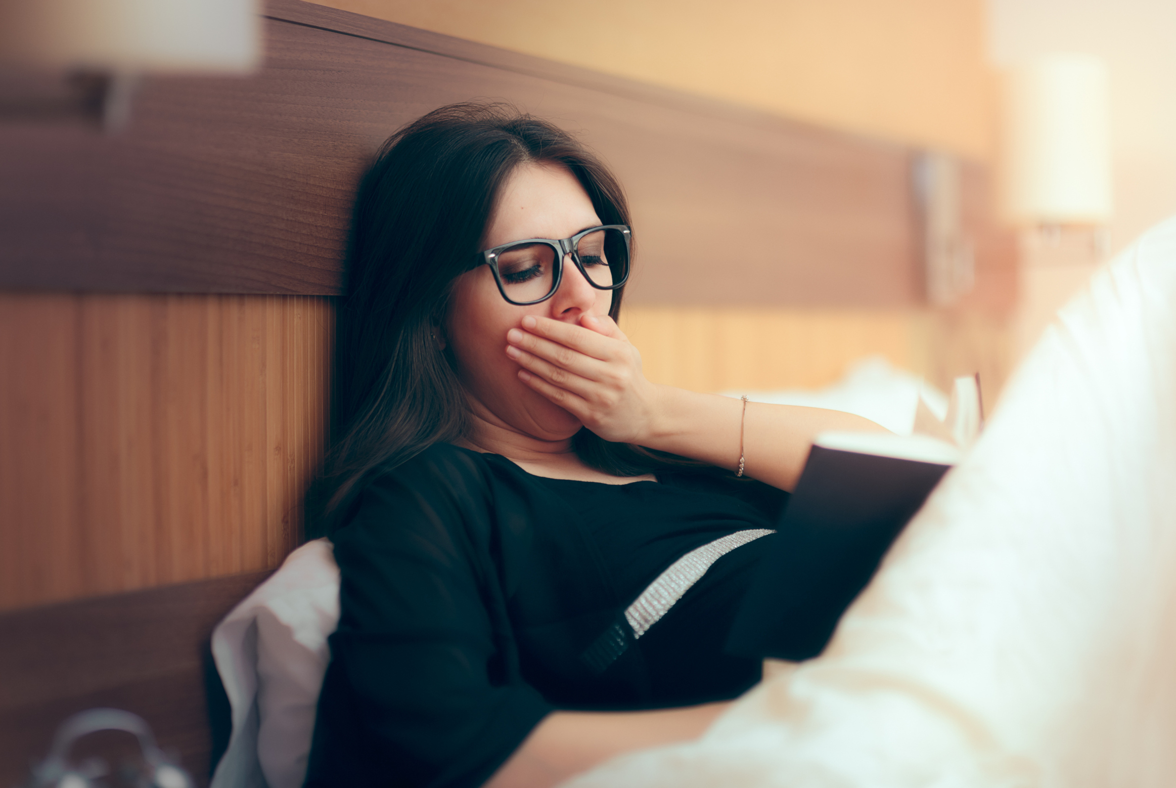 Frau gähnend im Bett