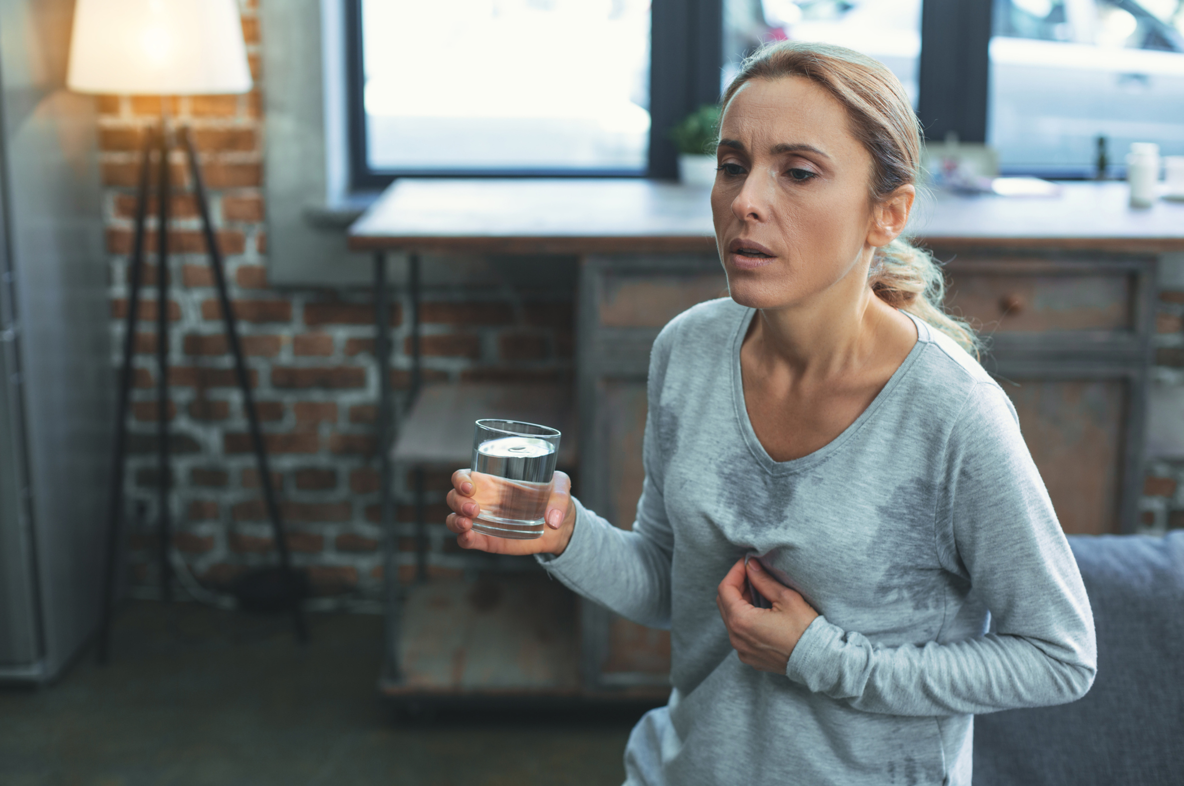 Frau verschwitzt mit Wasser in der Hand