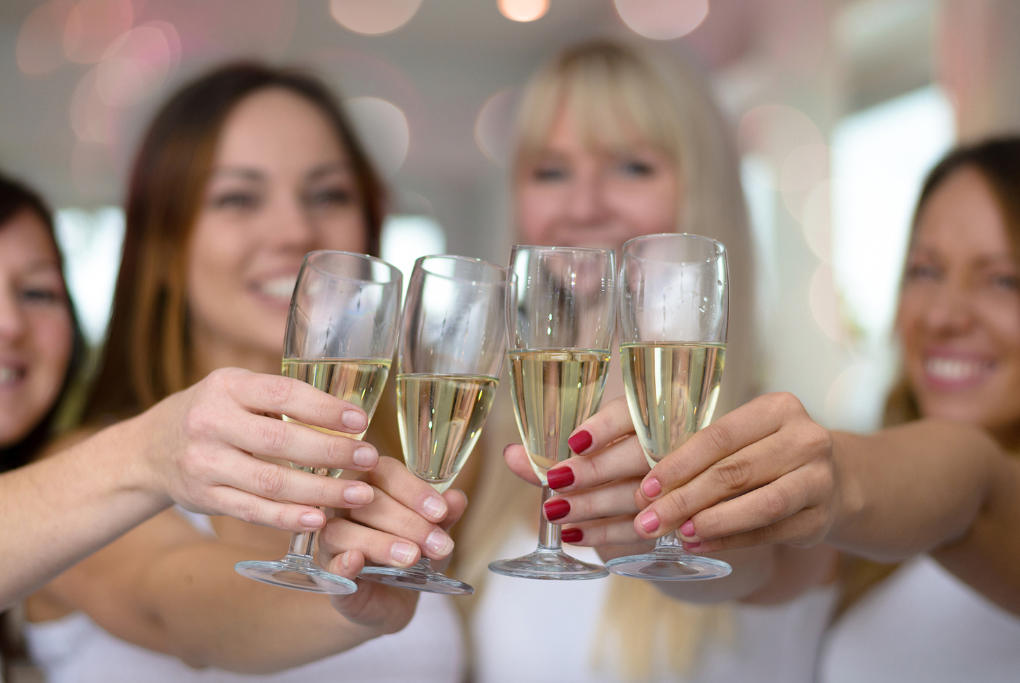 Avant le mariage: Quatre jeunes femmes trinquant avec des coupes de champagne
