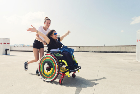 Frau schiebt Frau im Rollstuhl