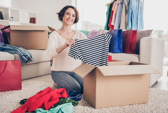 Frau mit Kisten und Kleidung