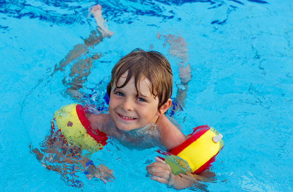 Kind mit Kraulquappen im Pool