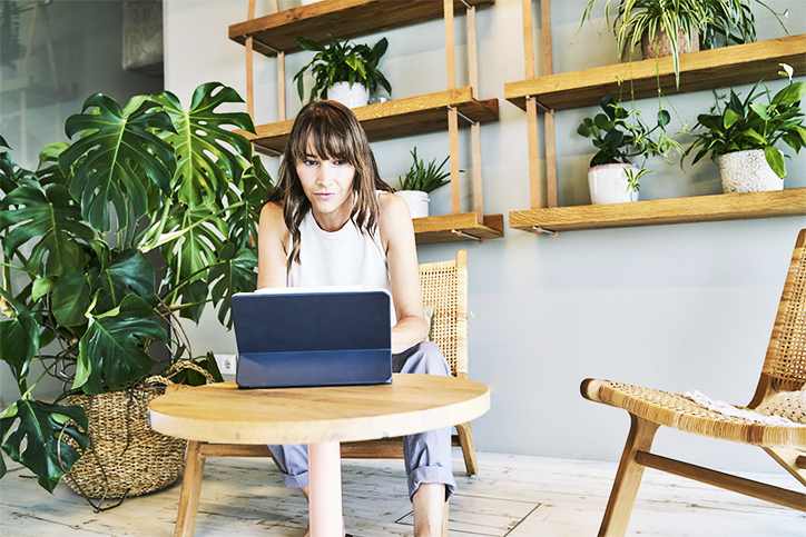 Frau arbeitet neben Pflanze