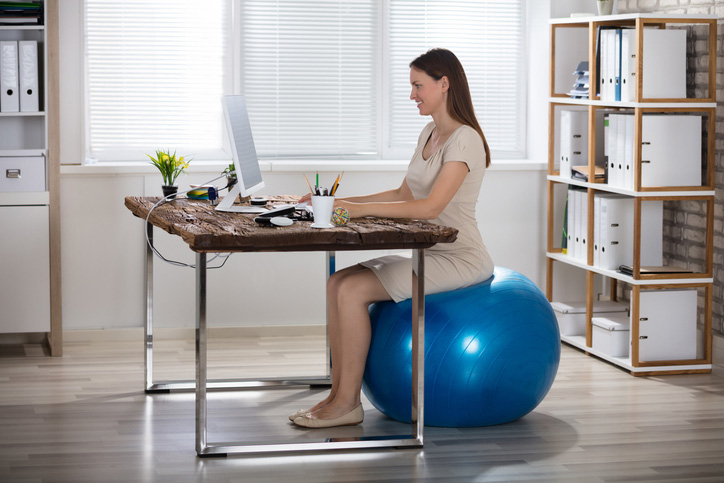 Frau arbeitet auf einem Sitzball